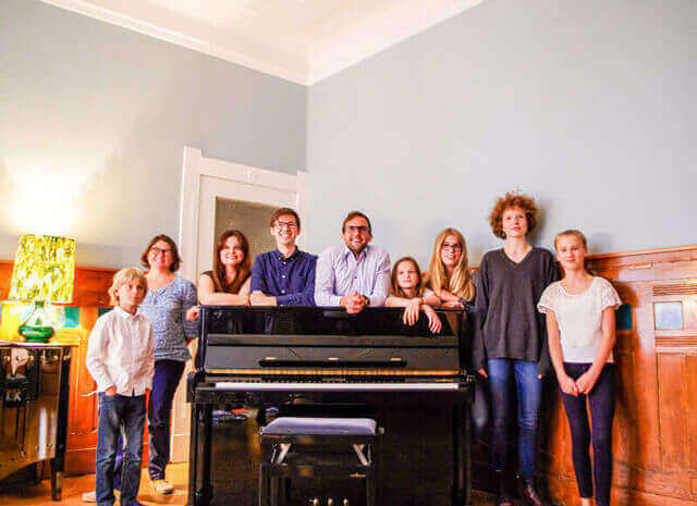Klavierlehrer mit Schüler*innen